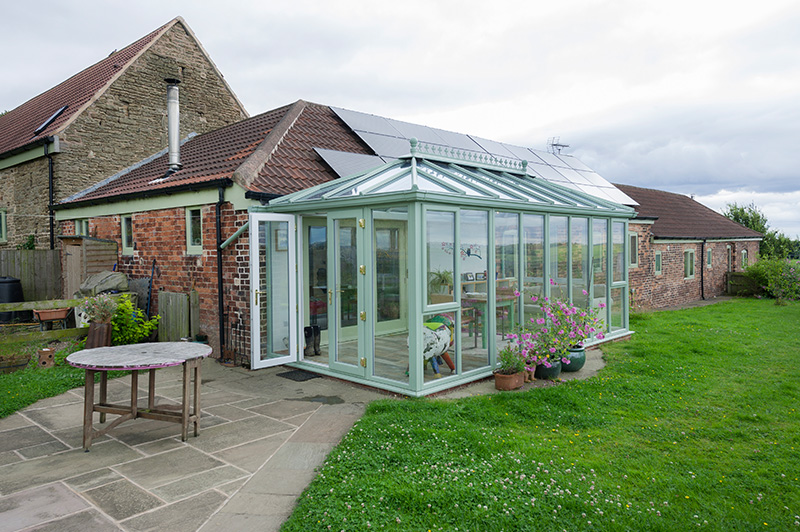 Light green framed uPVC conservatory with floor-to-roof windows and French doors in Leicester