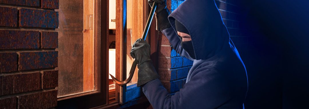 Attempted break-in at night through an old wooden window, highlighting the need for high-security windows from Abbey Windows Leicester