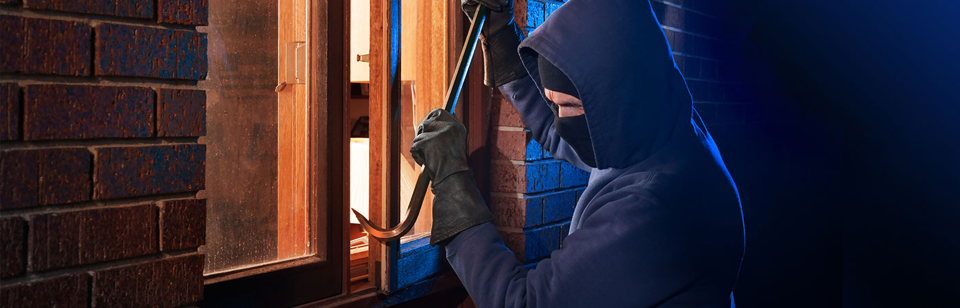 Attempted break-in at night through an old wooden window, highlighting the need for high-security windows from Abbey Windows Leicester